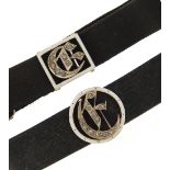 Two gold, white enamel and diamond buckle mourning bracelets with material straps, one marked 15ct