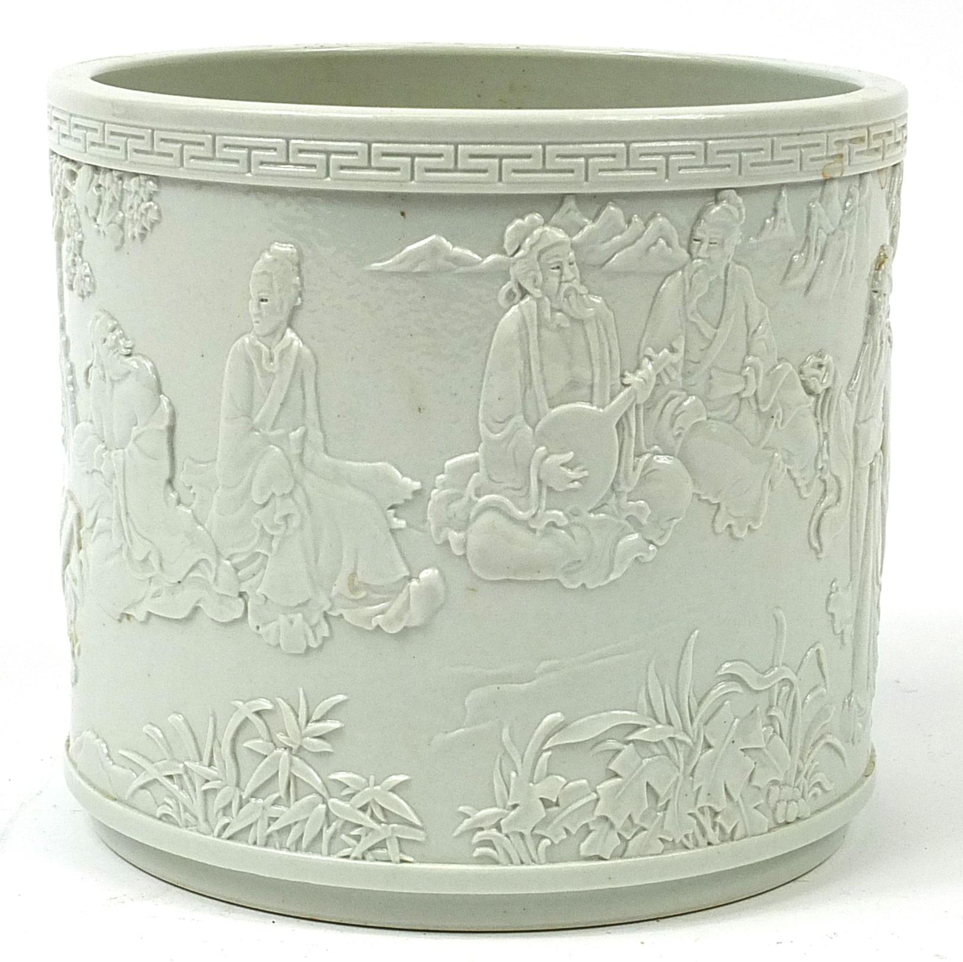 Chinese porcelain blanc de chine brush pot decorated in relief with an Emperor and figures in a