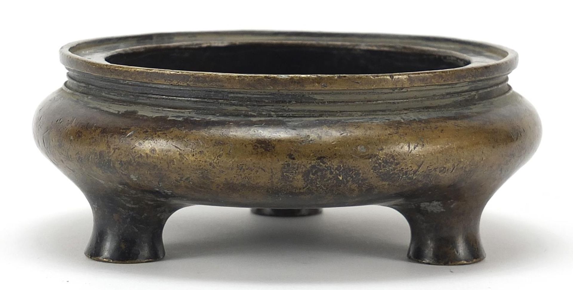 Chinese patinated bronze tripod censer, character marks to the base, 16cm in diameter