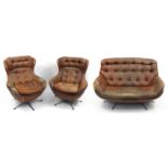 Vintage brown faux leather buttonback and chrome two seater settee and two egg type easy chairs, th