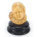 Carved ivory bust of a young boy raised on an ebonised base, 7cm high