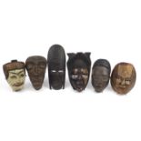 Six tribal interest carved wood face masks, the largest 31cm high