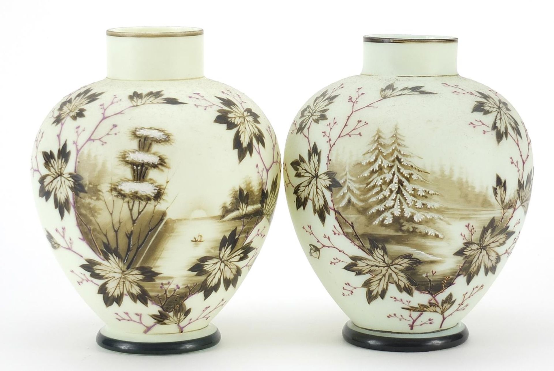 Pair of 19th century opaline glass vases hand painted with trees beside water within floral borders,