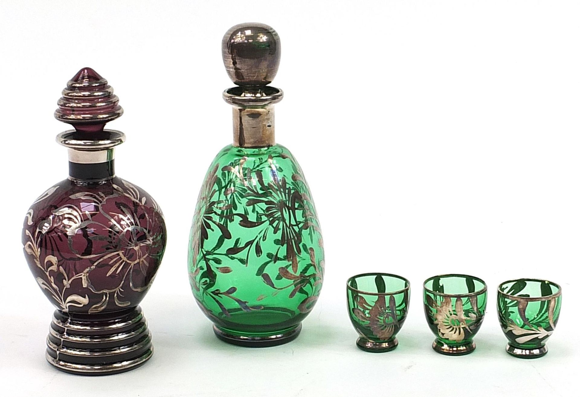 Two 1970's silver overlaid glass decanters and three glasses, the largest 22.5cm high