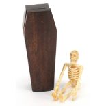 Japanese carved wood coffin enclosing an articulated carved bone model of a human skeleton, the
