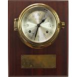 Kelvin Hughes brass ship's bulkhead design wall clock mounted on a mahogany back, 25.5cm high x 20cm