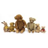 Group of antique and later straw filled bears and a rabbit, the largest 85cm high