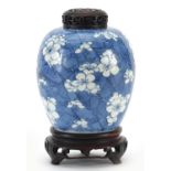 Chinese blue and white porcelain ginger jar hand painted with prunus flowers on carved hardwood