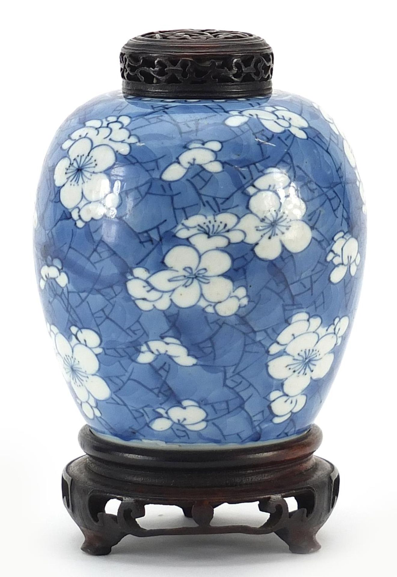 Chinese blue and white porcelain ginger jar hand painted with prunus flowers on carved hardwood