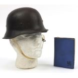 German military interest tin helmet with liner and a book
