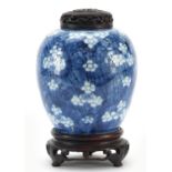 Chinese blue and white porcelain ginger jar hand painted with prunus flowers on carved hardwood