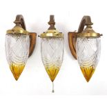 Three Secessionist style gilt metal wall lights with amber and clear glass shades, each 26cm high