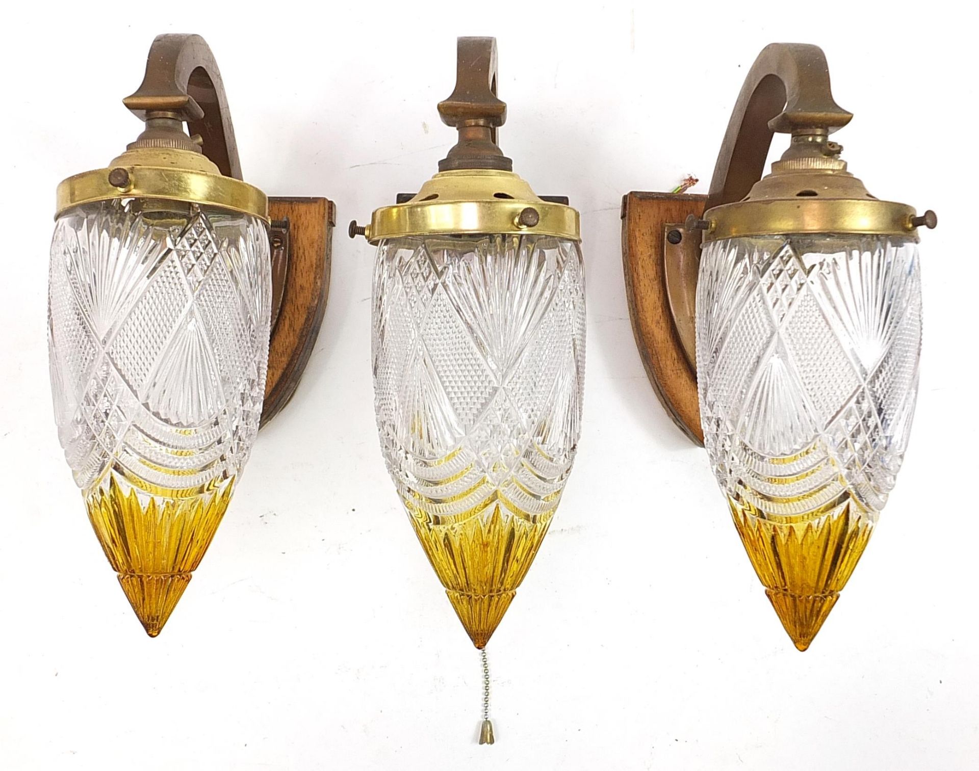 Three Secessionist style gilt metal wall lights with amber and clear glass shades, each 26cm high