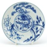 Chinese blue and white porcelain dish hand painted with a dragon amongst trees, six figure character