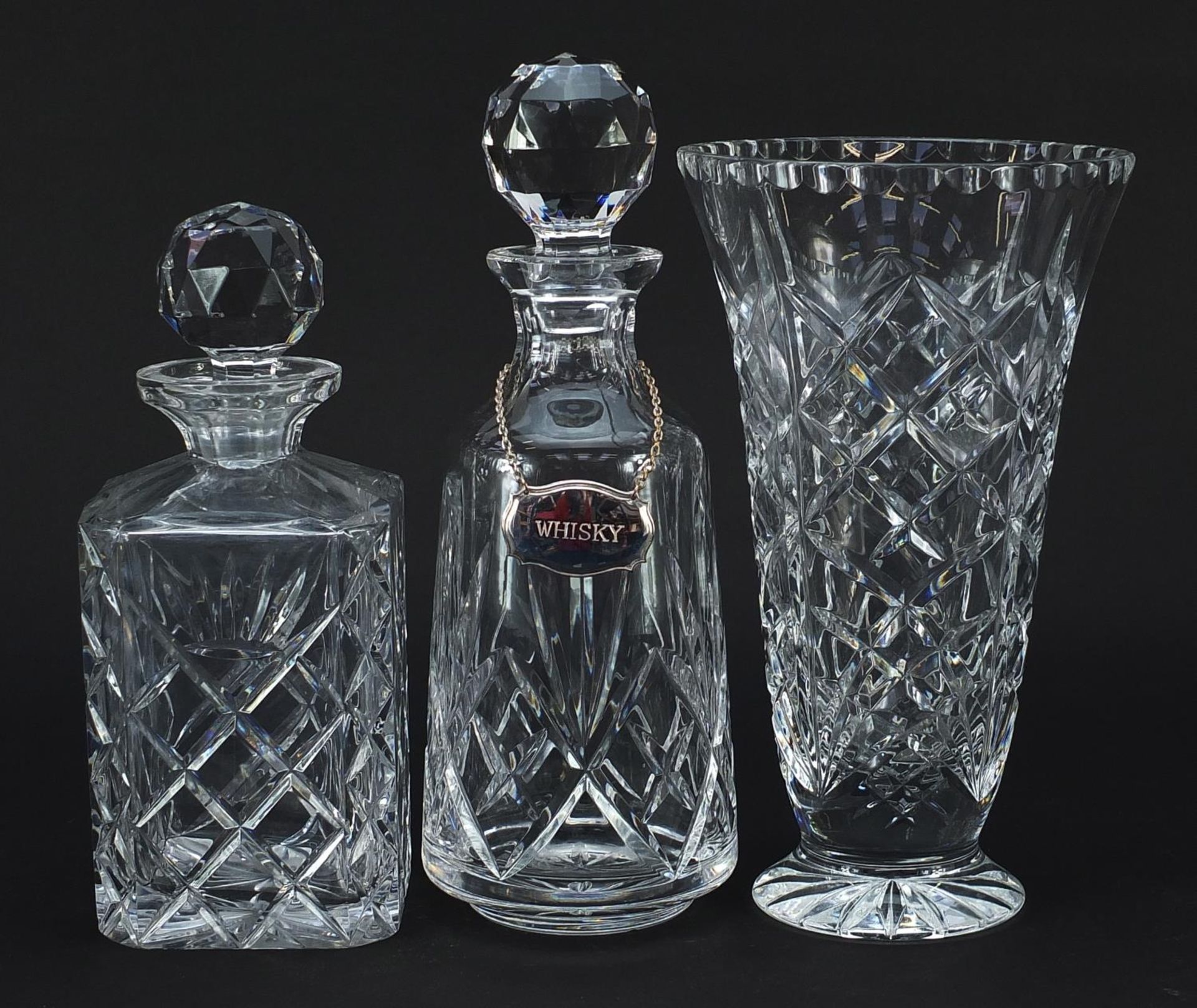 Two cut glass decanters with stoppers and cut glass vase, the largest 28.5cm high