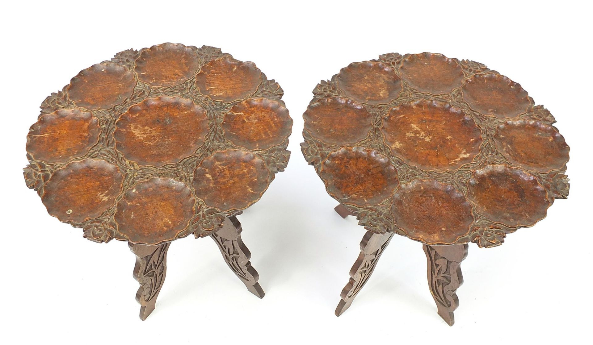 Pair of Anglo Indian carved folding circular tables, 45cm high x 41cm in diameter