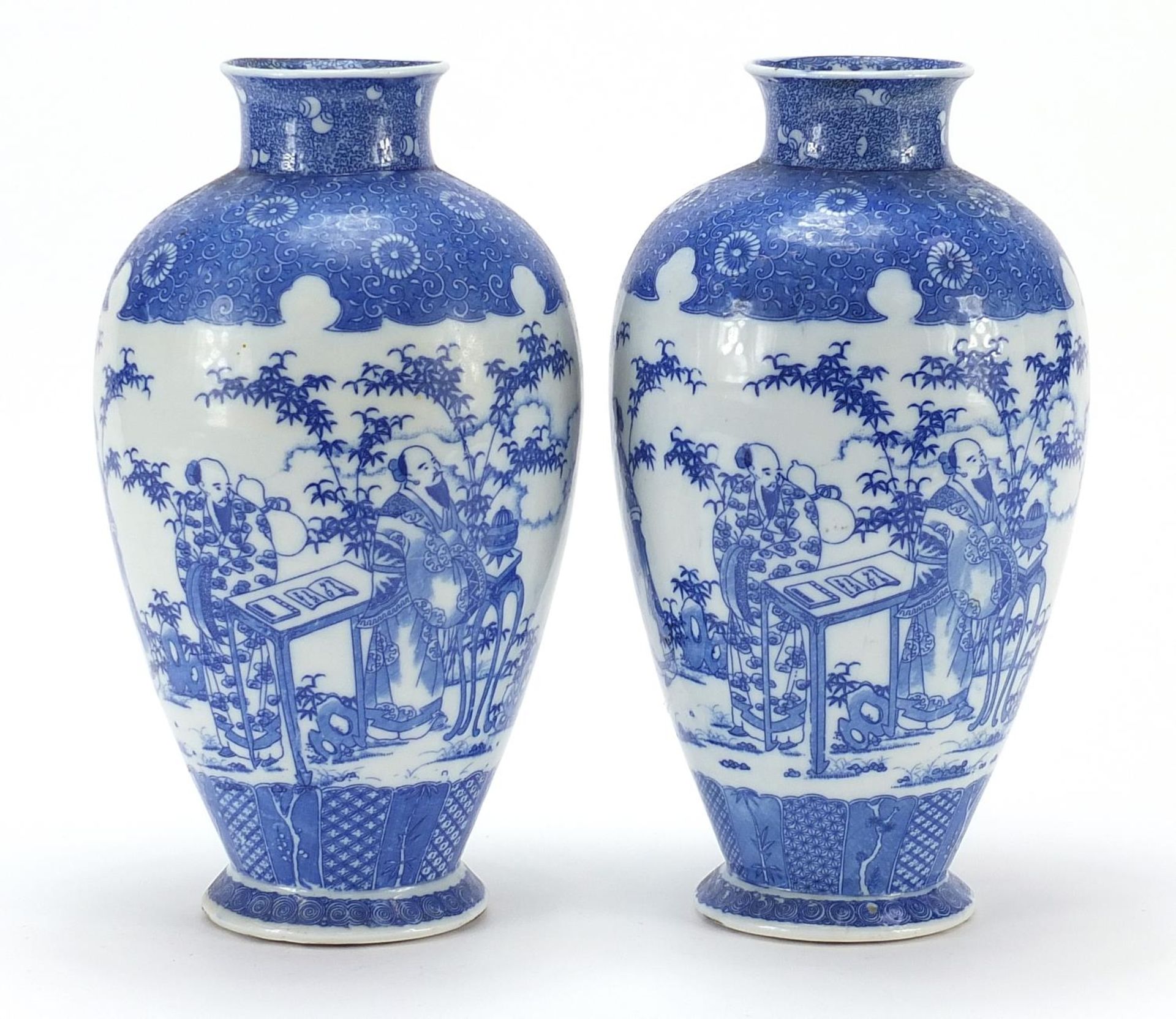 Pair of Japanese blue and white porcelain vases, each decorated with scholars in a landscape,