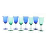 Two sets of four green and blue glass drinking glasses, 19cm high