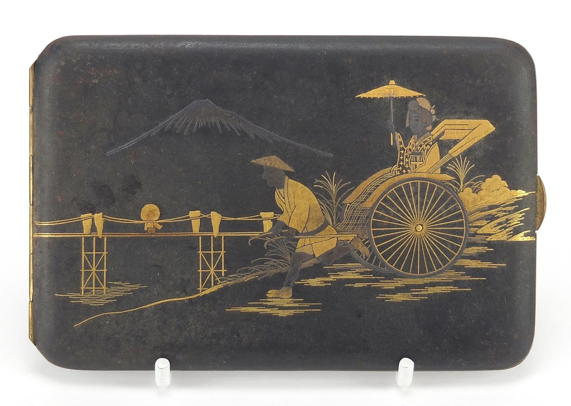 Japanese damascene cigarette case decorated with a figure pulling a rickshaw before Mount Fuji, 12cm