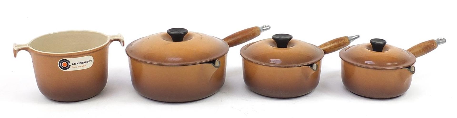 Three French Le Creuset saucepans with covers and one other cooking pot, the largest 21.5cm in
