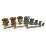 Three bronze pestle and mortars and set of five graduated pewter measures, the largest 24.5cm in