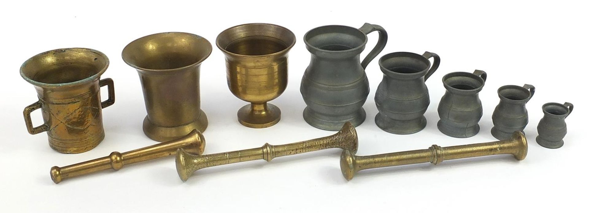 Three bronze pestle and mortars and set of five graduated pewter measures, the largest 24.5cm in