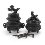 Two Japanese patinated bronze tripod incense burners and covers, the largest 16cm high