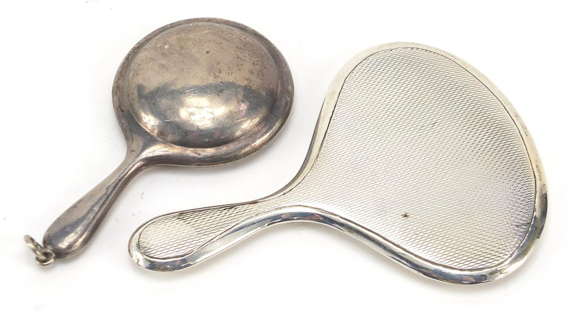 Two miniature silver hand mirrors, one with compact compartment, the largest 8cm in length, total