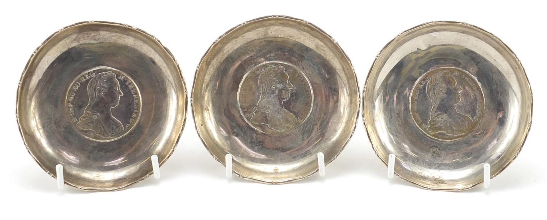 Three Chinese sterling silver Maria Theresa thaler coin dishes, 9cm in diameter, 182.4g