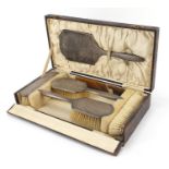 Henry Matthews, George V silver backed six piece dressing table set housed in a velvet and silk