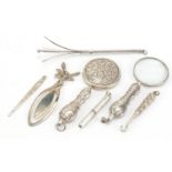 Silver objects including propelling swizzle stick, magnifying glass and button hook, the largest