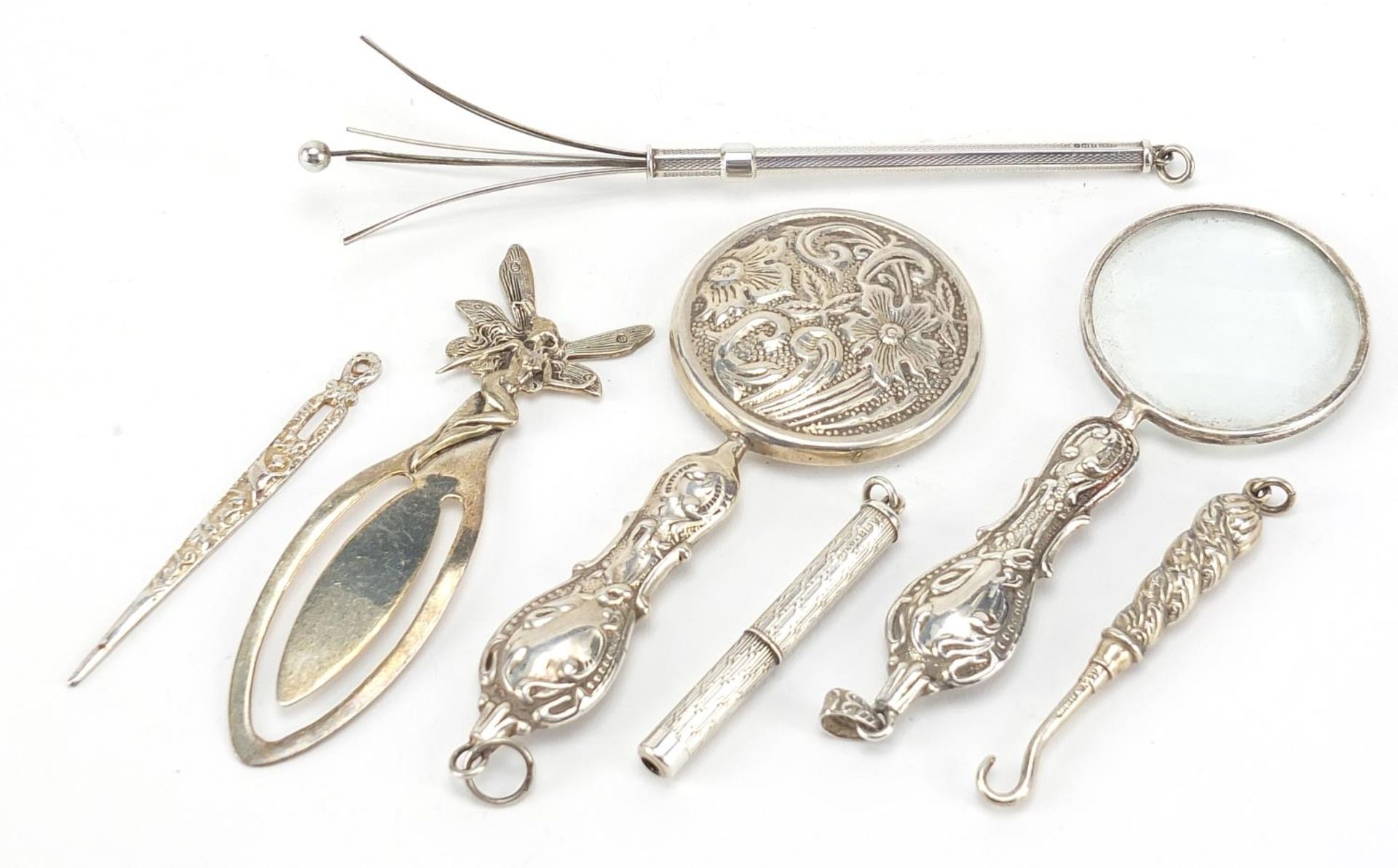 Silver objects including propelling swizzle stick, magnifying glass and button hook, the largest