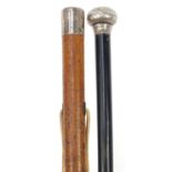 Two walking sticks with silver pommels including one with malacca shaft, the largest 90cm in length