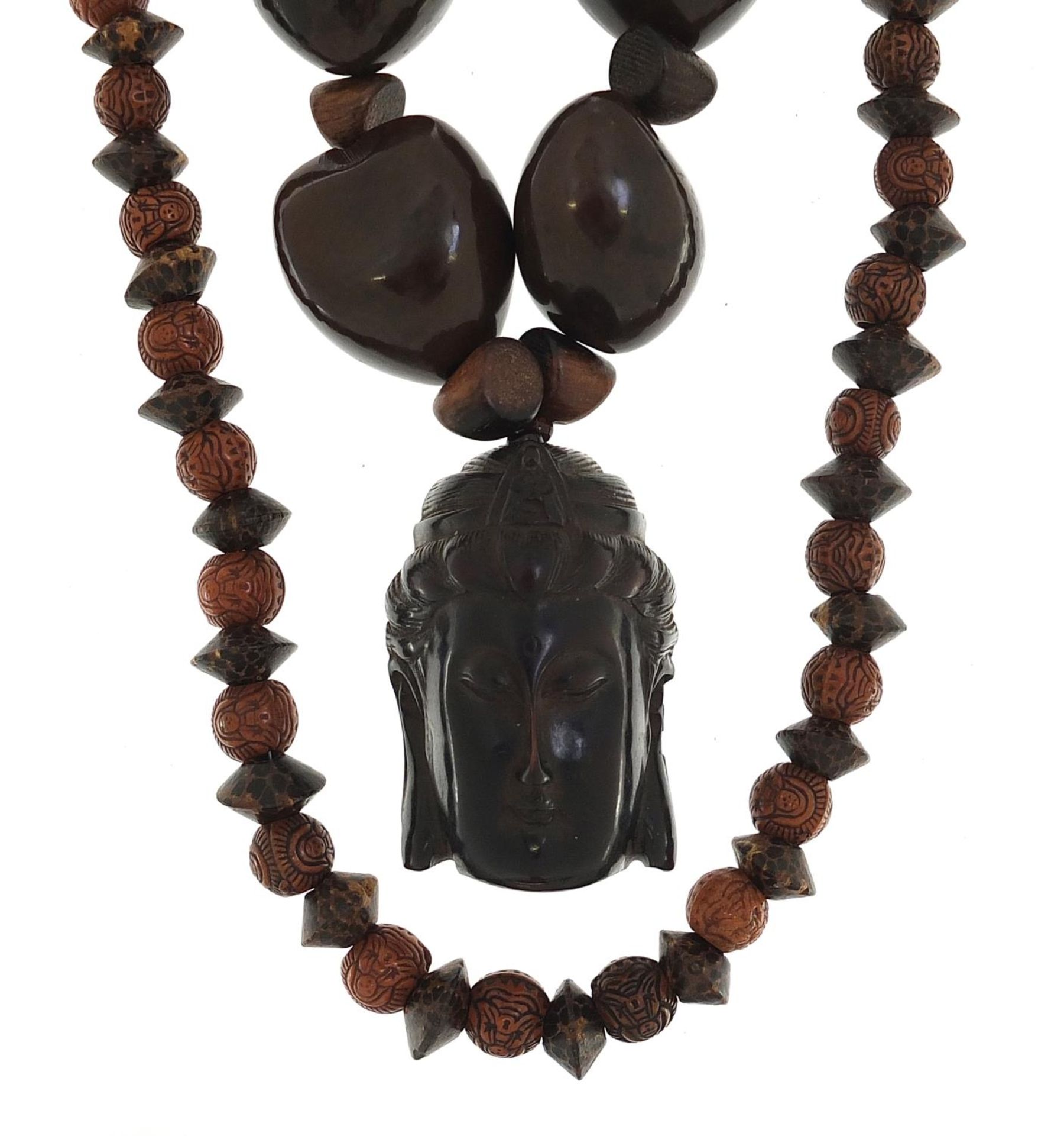 Two Asian bead necklaces including one with Chinese carved netsuke of a Buddha head