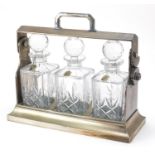 Mappin & Webb Sheffield silver plated tantalus with three crystal decanters, 34cm wide