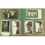 Edwardian and later topographical and social history postcards arranged in an album, some black