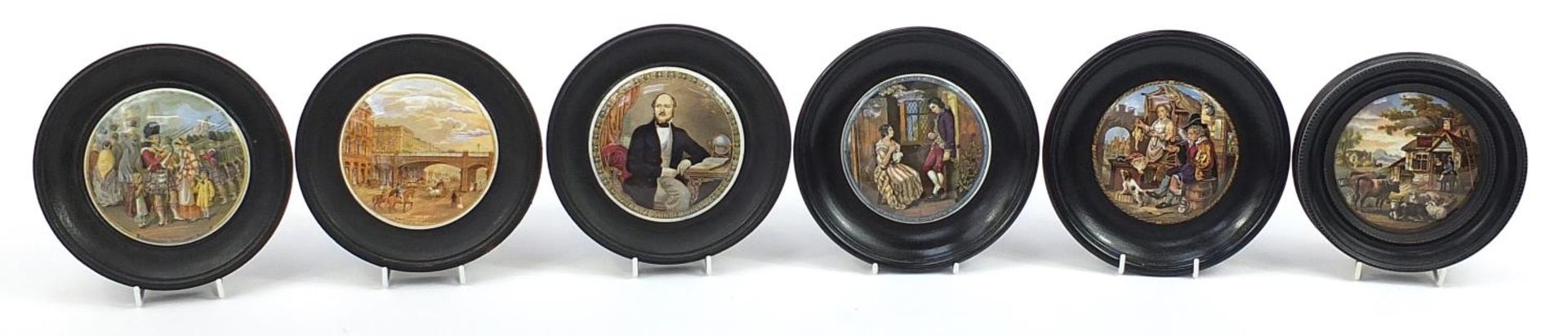 Six Victorian Staffordshire Prattware pot lids with ebonised wood frames, the largest 17cm in