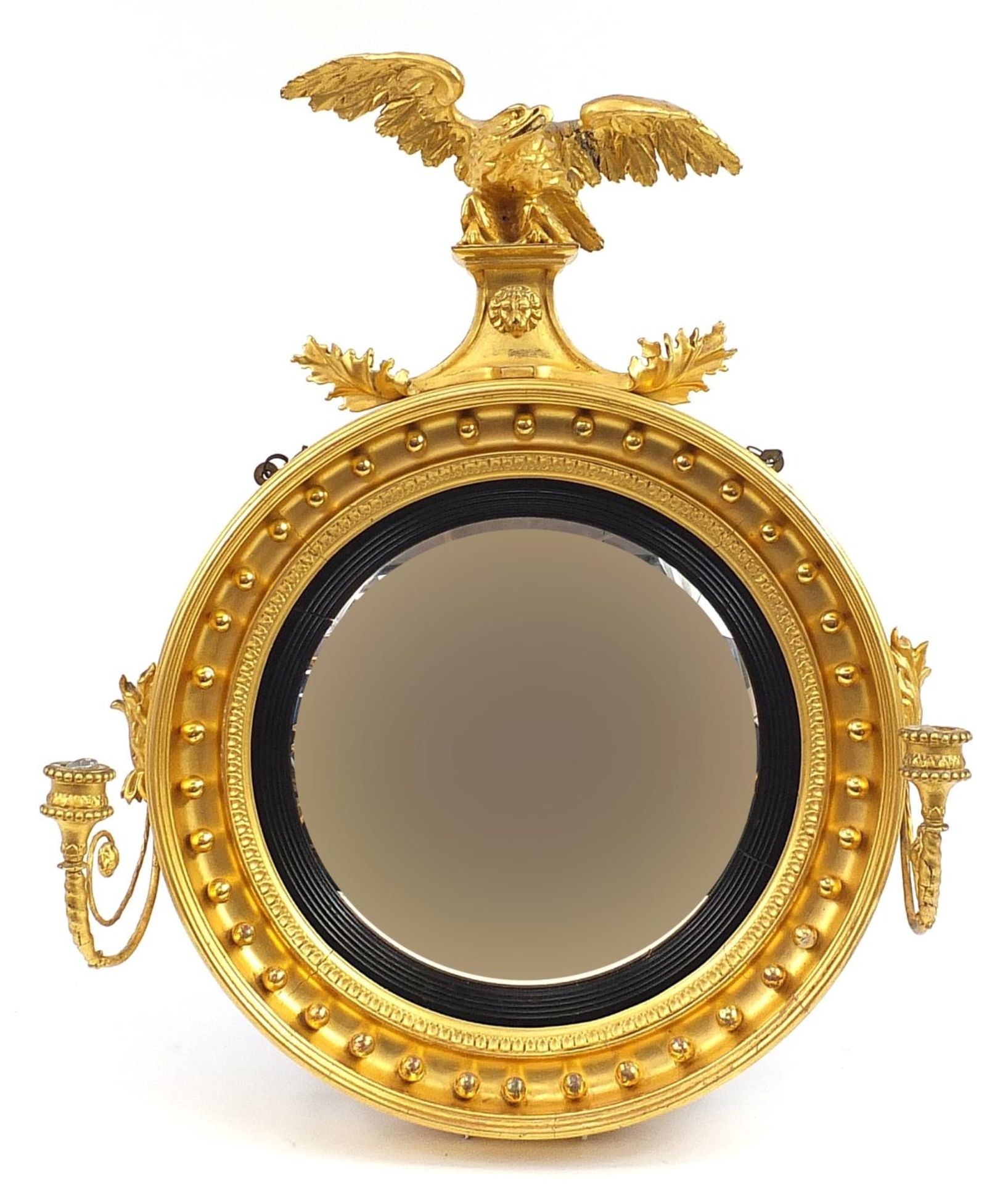 Regency giltwood convex wall mirror with sconces and eagle crest, 75cm high