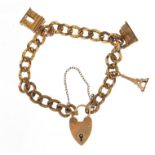 9ct gold love heart padlock on a charm bracelet with three yellow metal charms, total weight 27.6g