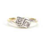 18ct gold and platinum diamond two stone crossover ring housed in a Spikins Wimbledon box, size L,