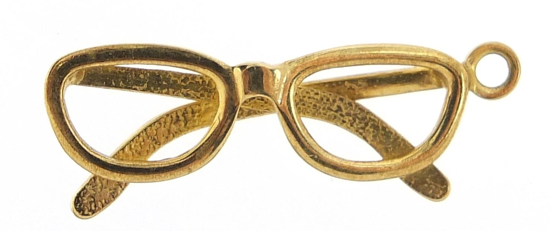 Unmarked gold pair of spectacles charm, (tests as 9ct gold) 2.2cm high, 1.3g