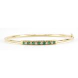 14ct gold emerald and diamond bangle, 6.3cm in diameter, 5.5g