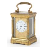 Miniature brass cased carriage clock with floral chased decoration, the circular enamelled dial with