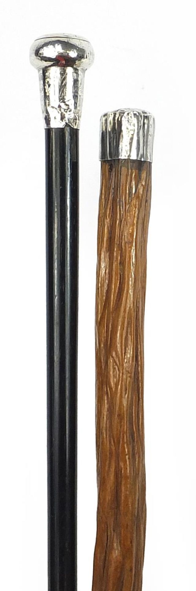 Two walking sticks with silver handles including an ebonised example, the largest 91cm in length