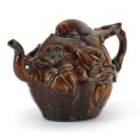 19th century Chinese style treacle glazed teapot decorated in relief with peaches, 17cm in length