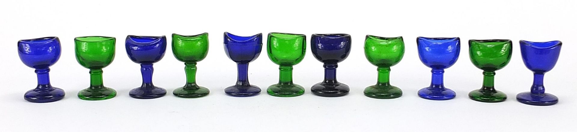 Eleven antique glass eye baths including six Bristol blue examples, each approximately 7.5cm high