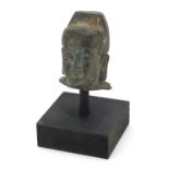 Chinese patinated bronze head of an Emperor on ebonised wooden stand, overall 7cm high