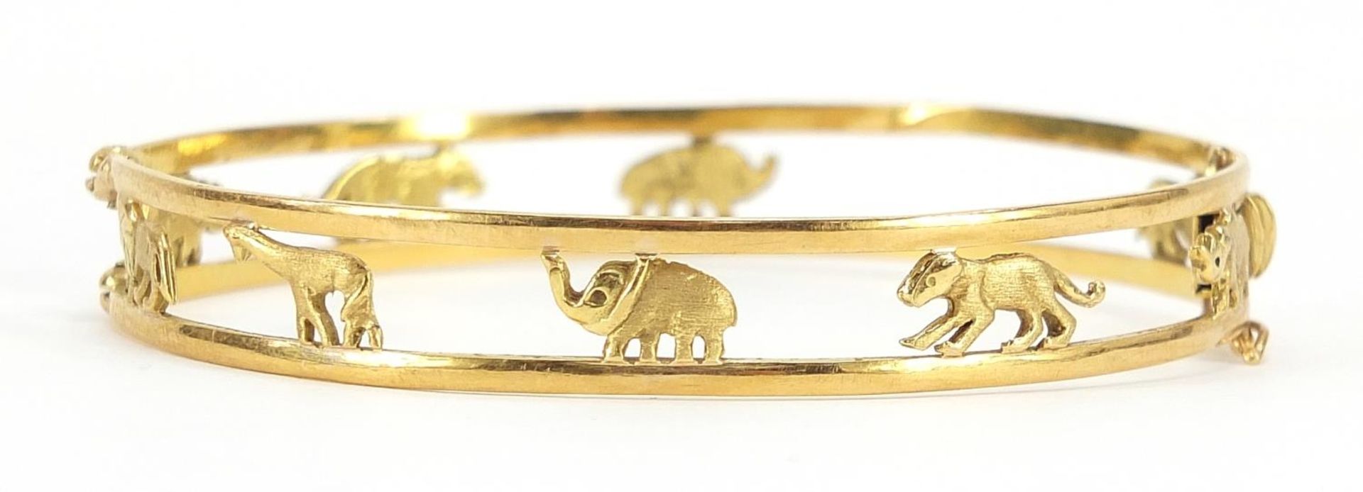 18ct gold hinged bangle pierced with animals including lion, giraffe, elephant and rhino, housed