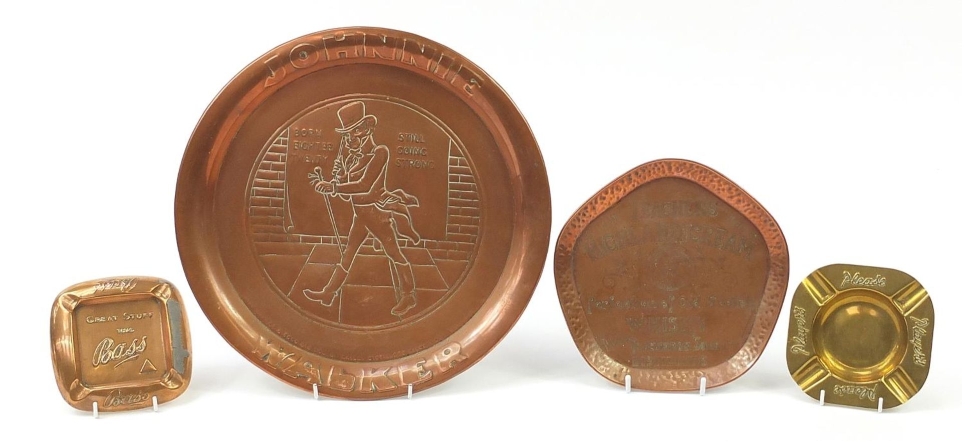 Four copper and brass advertising trays and ashtrays comprising Johnnie Walker, Teacher's Highland