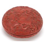 Chinese cinnabar lacquered bun box and cover carved with Foo dogs amongst clouds, 18cm in diameter